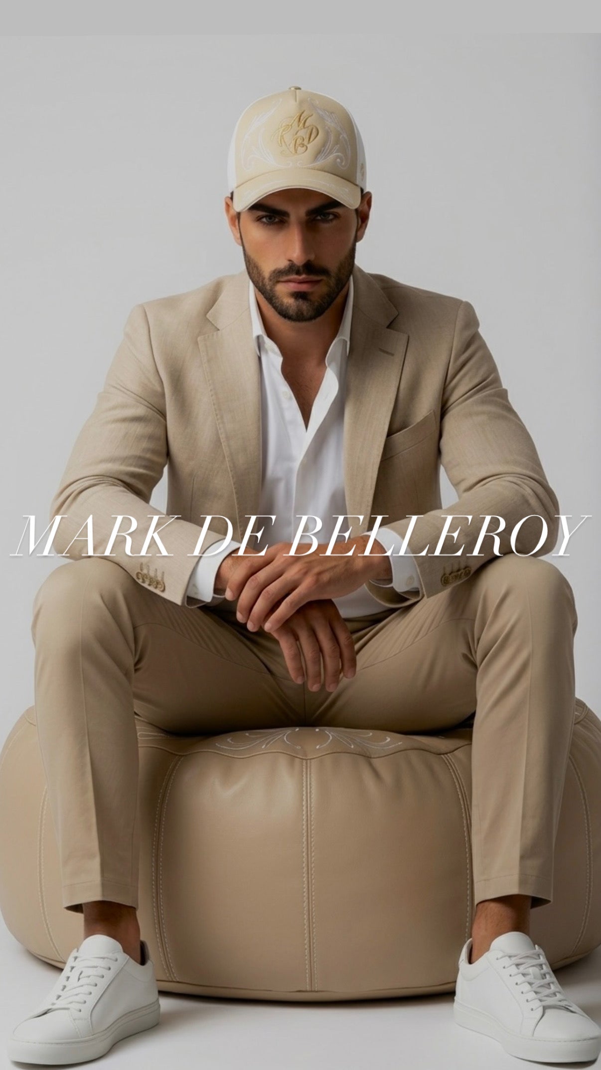 Homme élégant portant une casquette beige et blanche brodée Mark De Belleroy, fabrication artisanale française haut de gamme