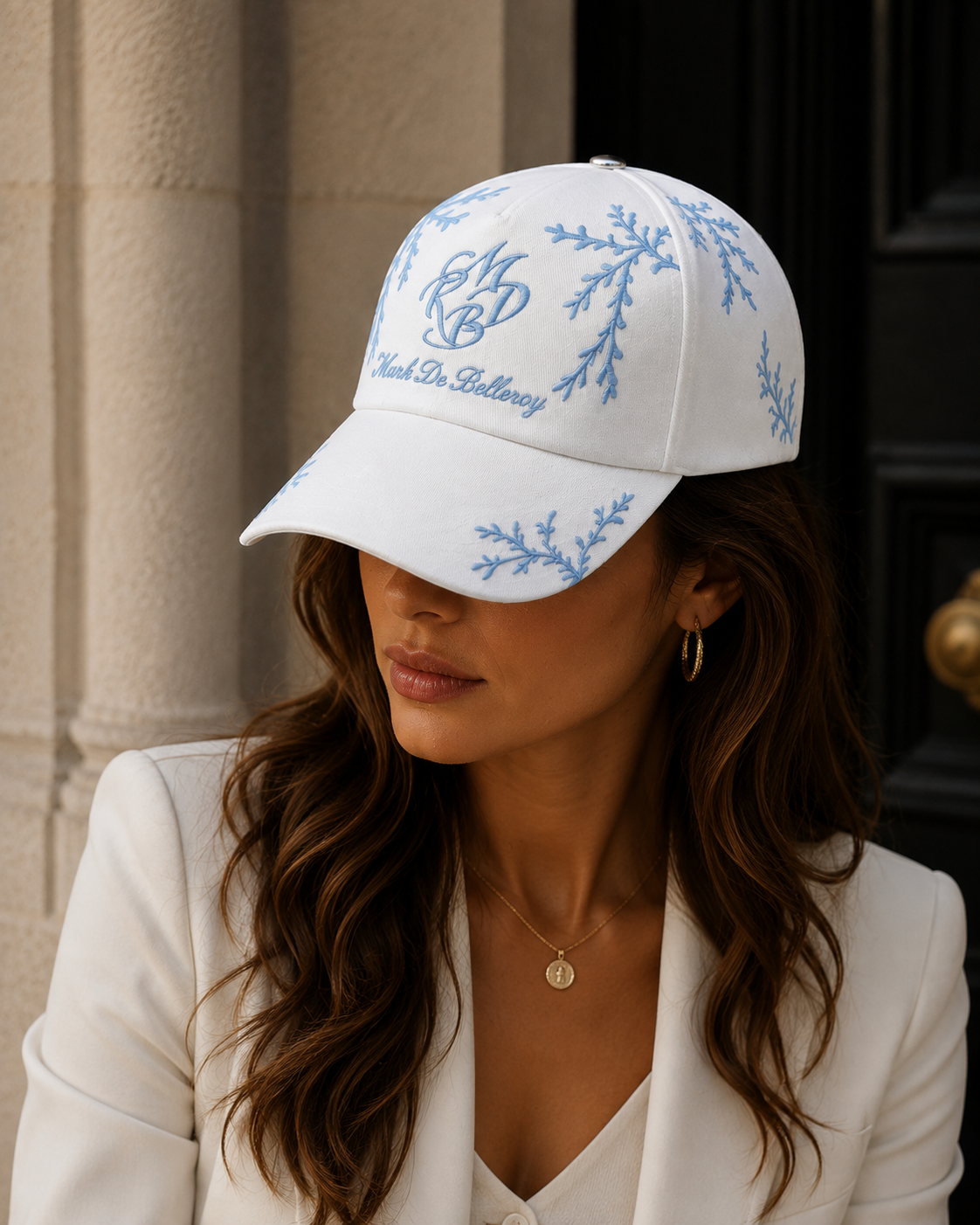 Casquette baseball de luxe L'Éclat Céleste portée par une femme, blanc et branchage bleu ciel, Mark De Belleroy