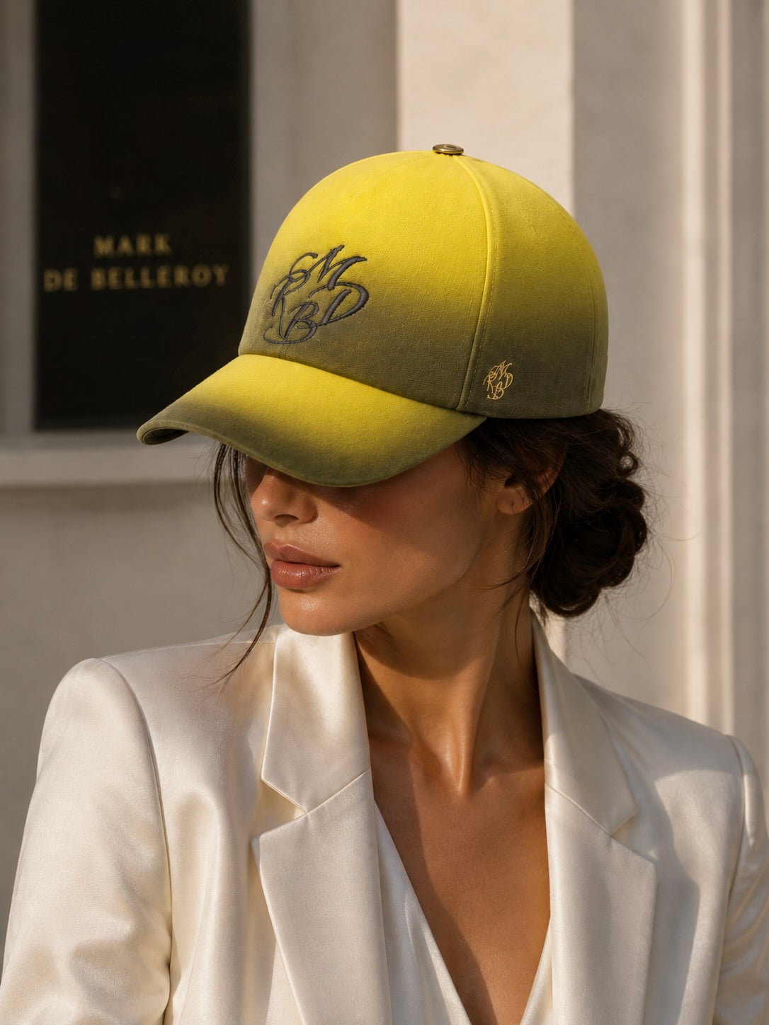 Woman wearing a yellow-and-black gradient Prestige cap embroidered with “Made in France”