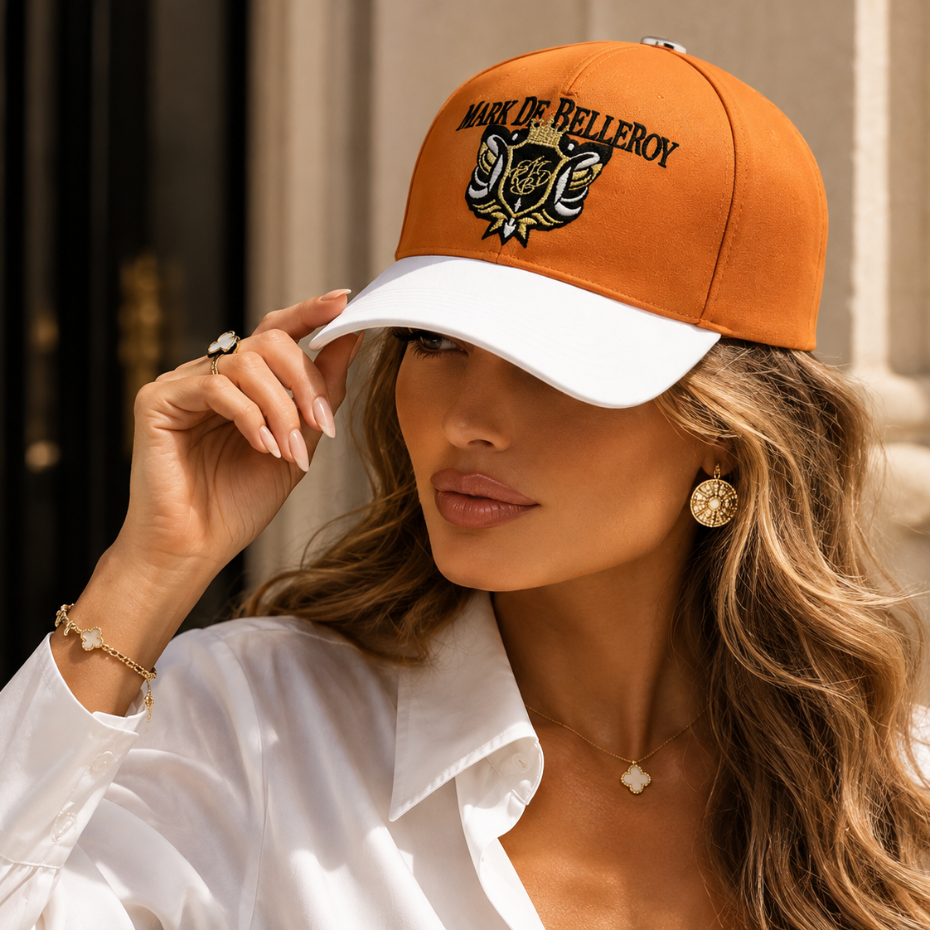 Woman wearing a luxury Mark De Belleroy cap. Elegant peach and white cap with gold embroidery and silver details. Made-in-France cap.