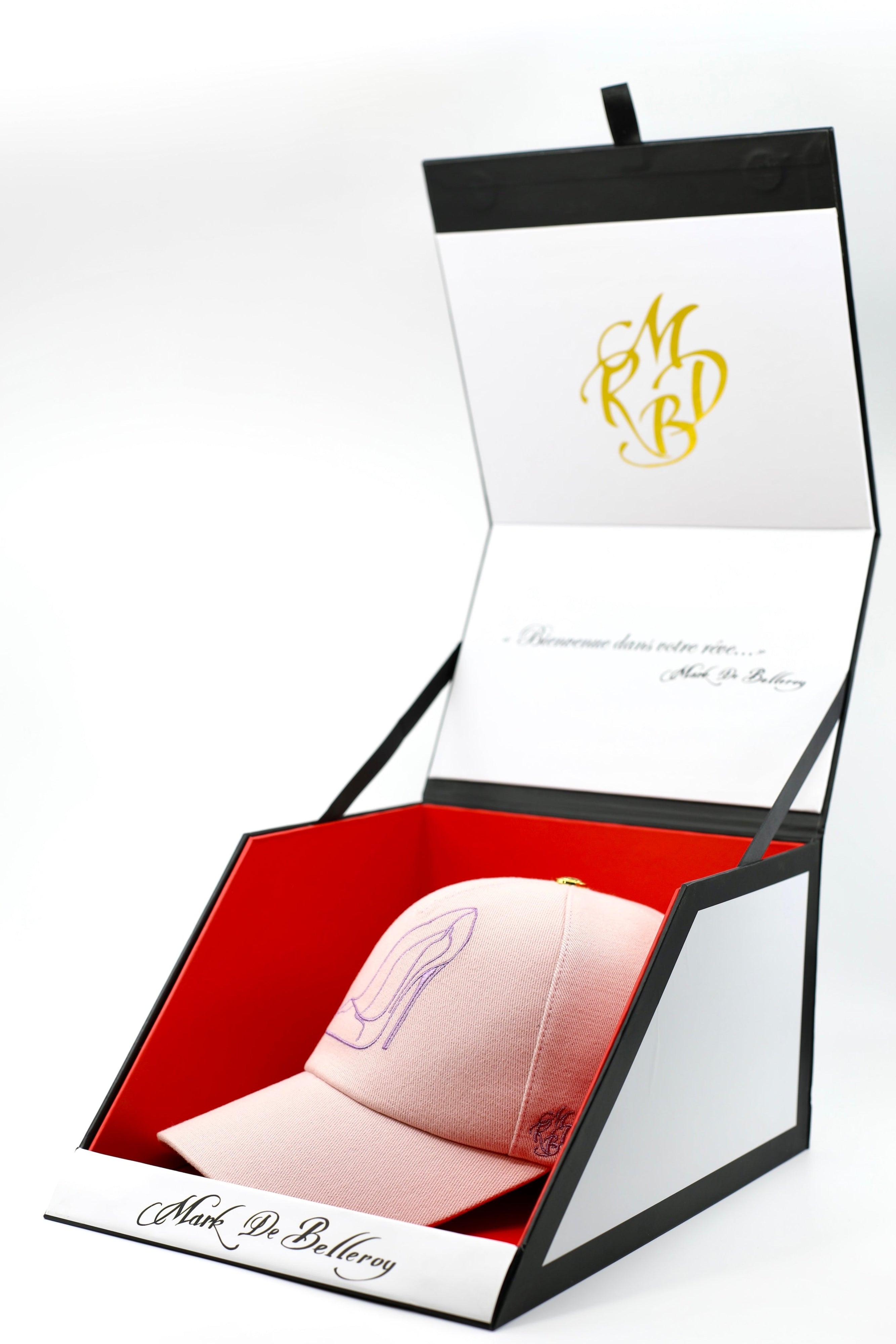 Casquette trucker de luxe rose poudré l'escarpin poudré par Mark De Belleroy dans son écrin à casquette signature 